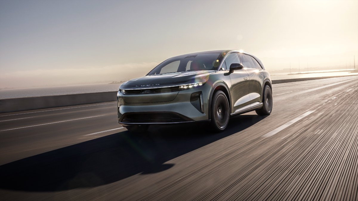 2026 Lucid Gravity electric SUV in metallic gray, dynamic side angle driving on highway at sunset