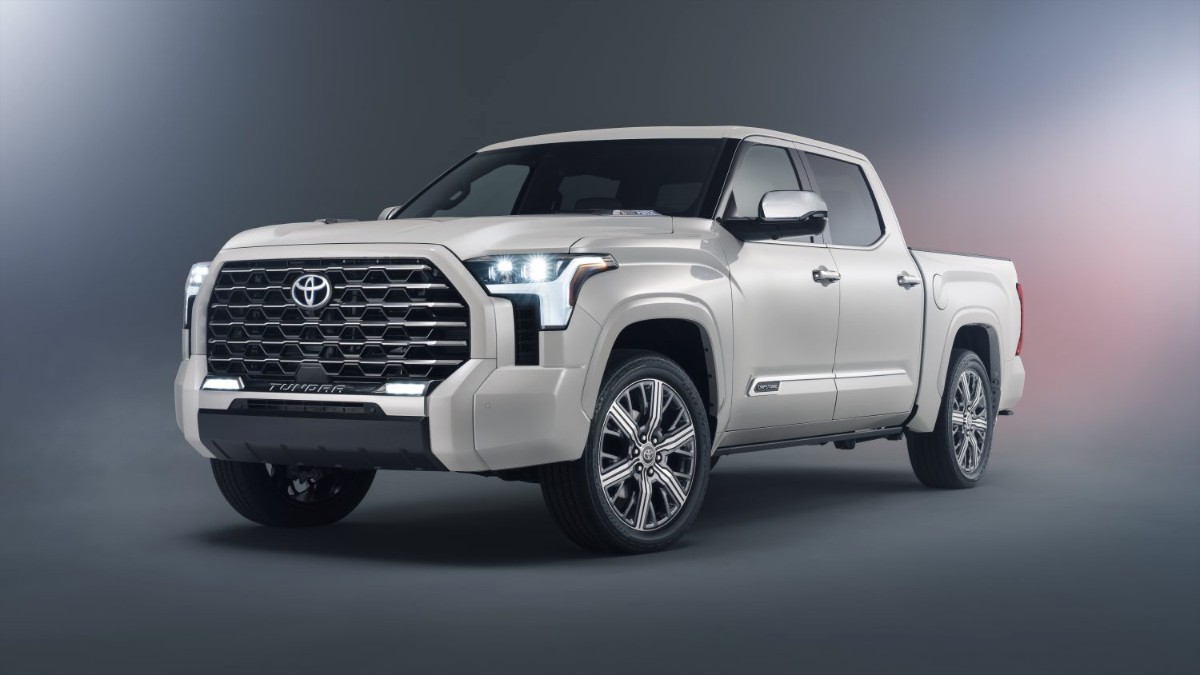 Pearl white Toyota Tundra pickup truck with bold grille, LED headlights, angled front three-quarter view on gradient background