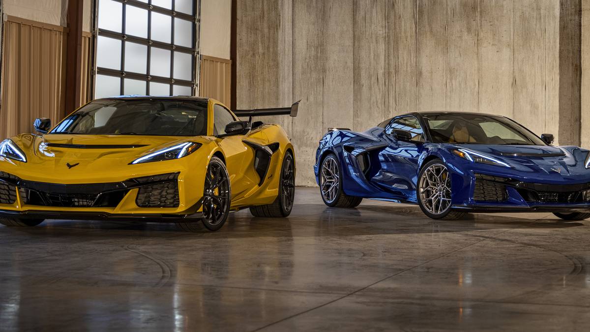 A striking yellow and blue Chevrolet Corvette Z06 coupe and convertible sit side-by-side in a modern garage.