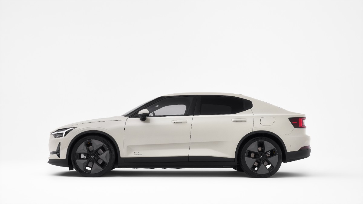 2025 Polestar 2 in white, side view, showcasing black wheels and distinctive body lines against a plain background.
