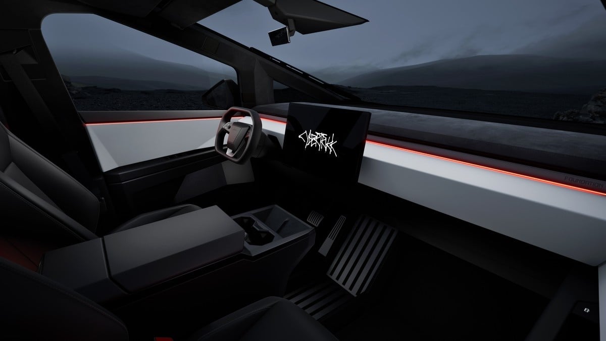 2025 Tesla Cybertruck interior with minimalist dashboard, illuminated accents, and a central display screen.
