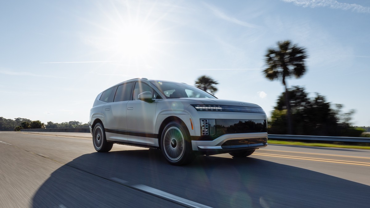 2025 Hyundai Ioniq 9 electric SUV driving on highway with palm trees in background