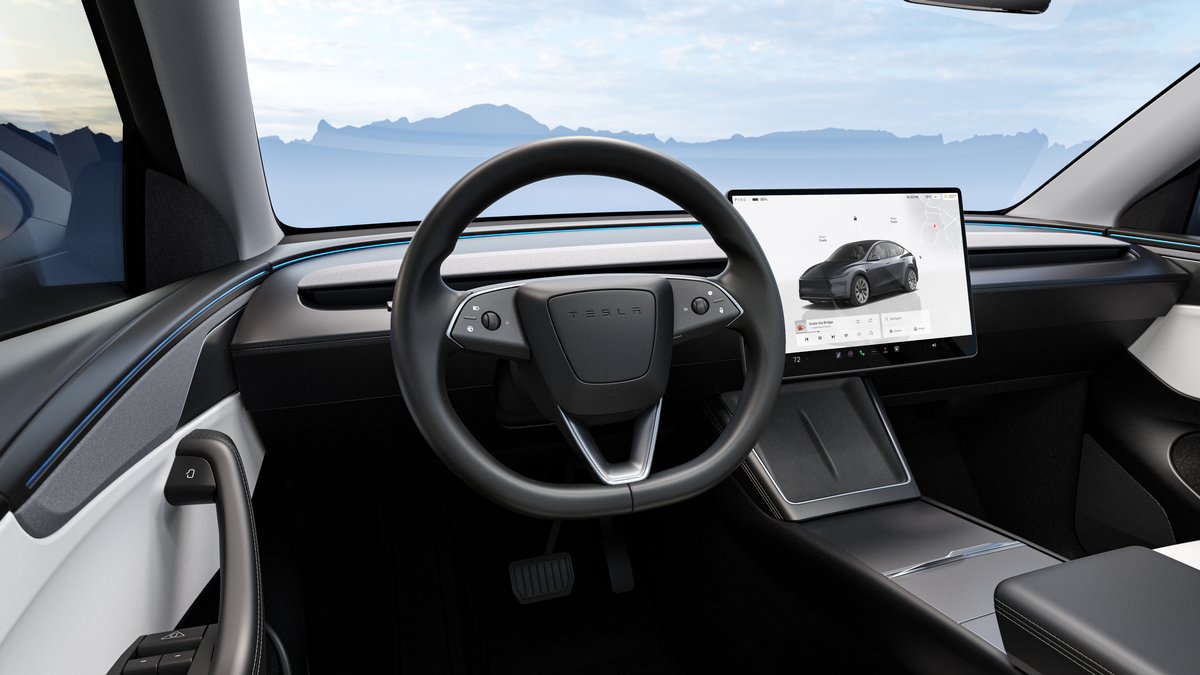 Interior view of a 2026 Tesla Model Y Juniper featuring a sleek steering wheel, large touchscreen display, and modern dashboard design.
