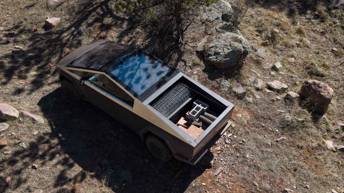 Bird's-eye view of a Tesla Cybertruck parked on rocky terrain, featuring an open bed filled with materials like bricks and wire.