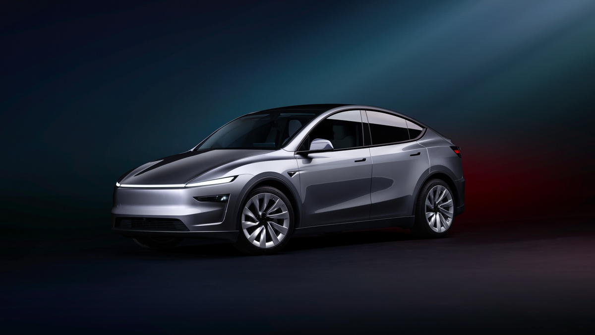 A silver Tesla Model Y Juniper showcased against a dark gradient background, highlighting its aerodynamic design and futuristic features.