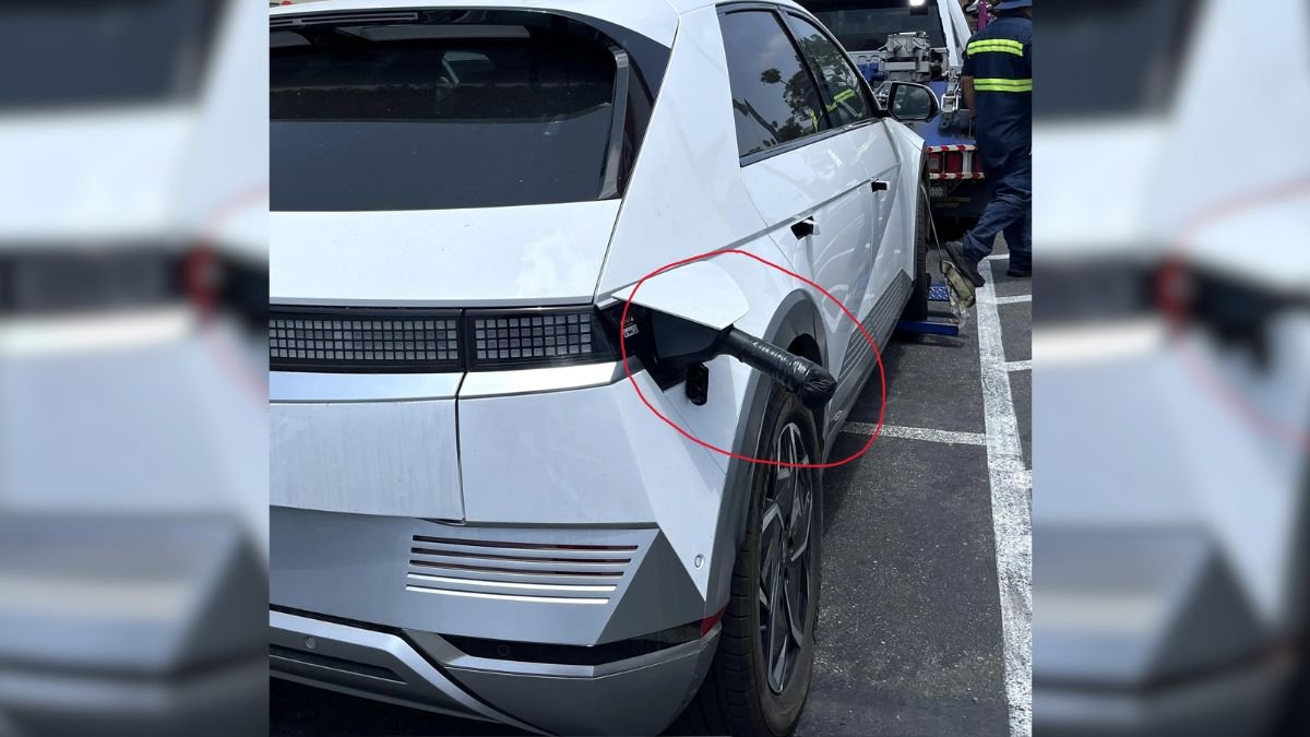 A white electric vehicle parked with a charging port visible, showcasing modern design and unique rear features.