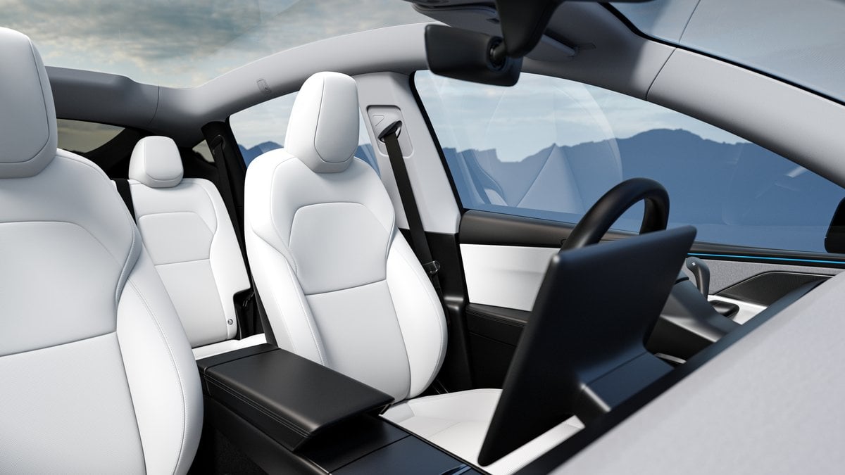 2026 Tesla Model Y Juniper interior featuring sleek white leather seats, minimalist design, and a centrally positioned touchscreen display.