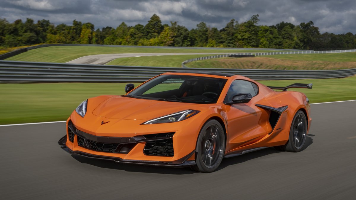A 2024 c8 Corvette, the Chevrolet Corvette, races along a winding track under a partly cloudy sky.