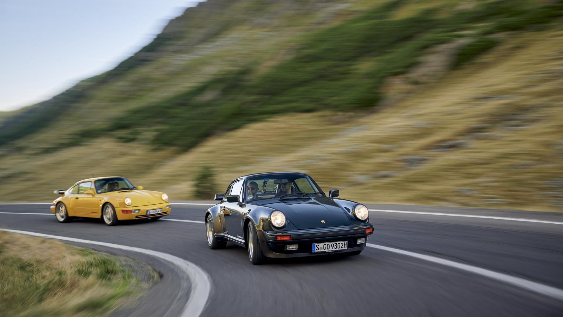 Porsche 930 Turbo leading a pack of Porsche 911s on a twisty road