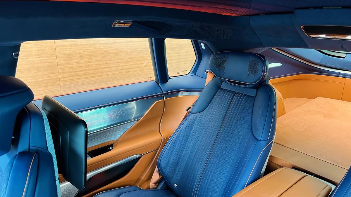 2026 Cadillac Celestiq car interior featuring a plush blue and orange seat, sleek dashboard, and a personal screen, emphasizing comfort and elegance.