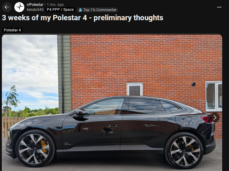 Black Polestar 4 parked outdoors, showcasing sleek design and distinctive wheel rims against a brick wall background.
