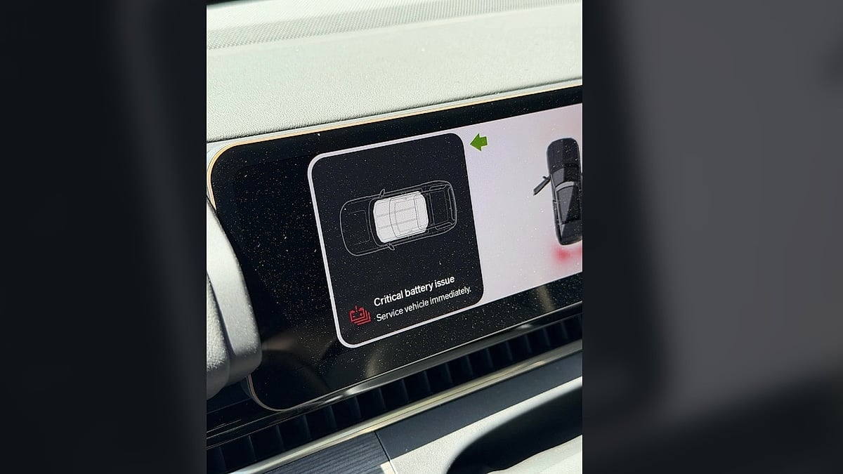 Rivian dashboard screen showing a critical battery issue warning and service message.