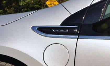 The Chevy Volt charging door and logo with a gas line sign in the background