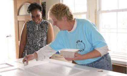 Home owner Courtenay LaRoche watches St. Bernard Project volunteer Sharon Jenks 